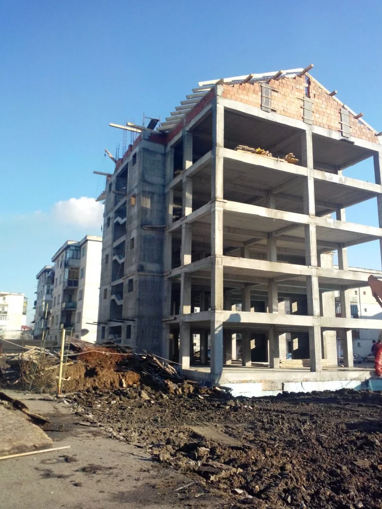 Structură de clădire cu mai multe niveluri pe un șantier.